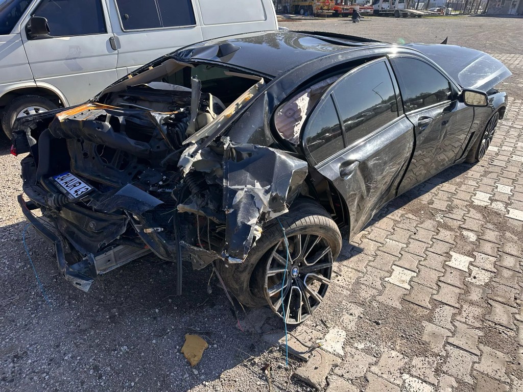 Arkası ağır hasarlı siyah sedan