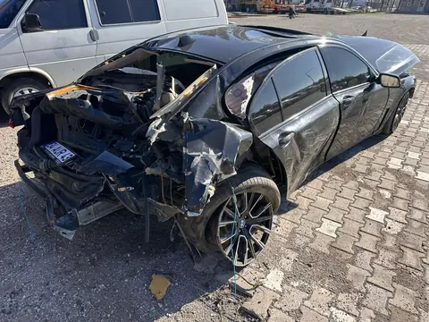 Arkası ağır hasarlı siyah sedan